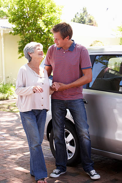 istock Man Helping Senior Woman Into Car 155430341