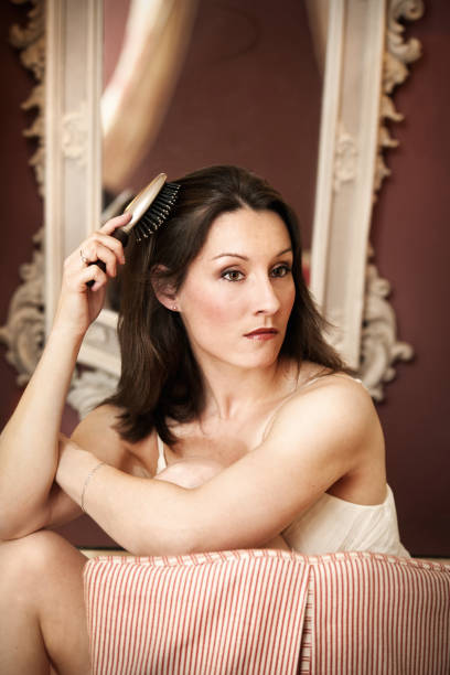 женщина причёсывать ее волосы - dressing room women female adult стоковые фото и изображения