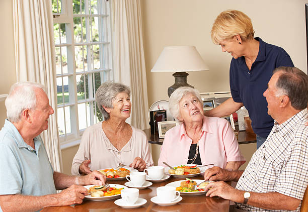istock Group Of Senior Couples Enjoying Meal Together With Home Help 155430479