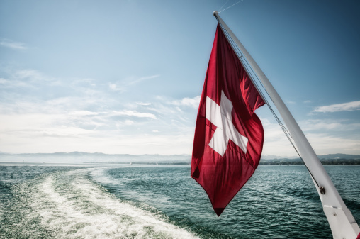 Swiss flag waving in the wind during a sailing boat trip