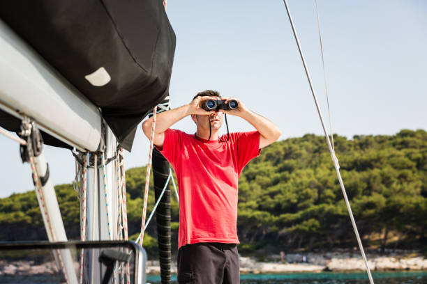 istock Sailor with binoculars on sailboat 1554308293