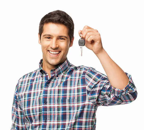 Portrait of a cheerful young man holding car key. Horizontal shot. Isolated on white.