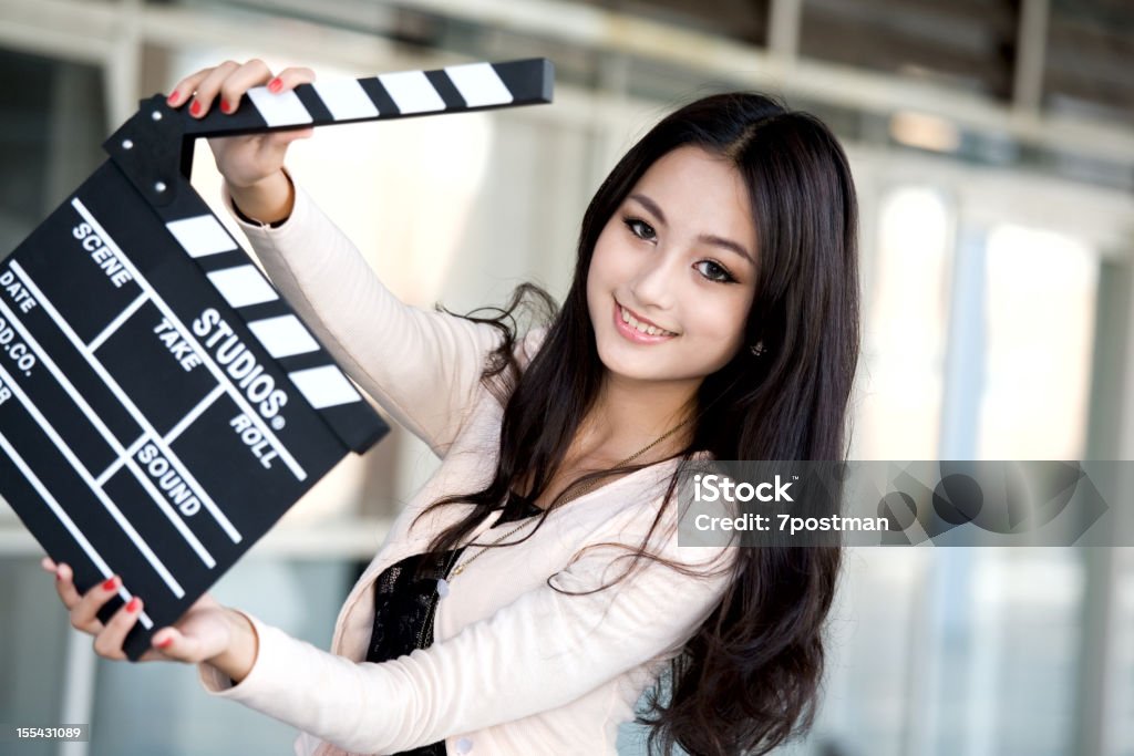 Bella giovane donna che tiene un clapper - Foto stock royalty-free di Attore