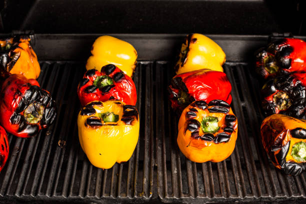 istock Many colorful peppers in a row roasting on a grill. 155431171
