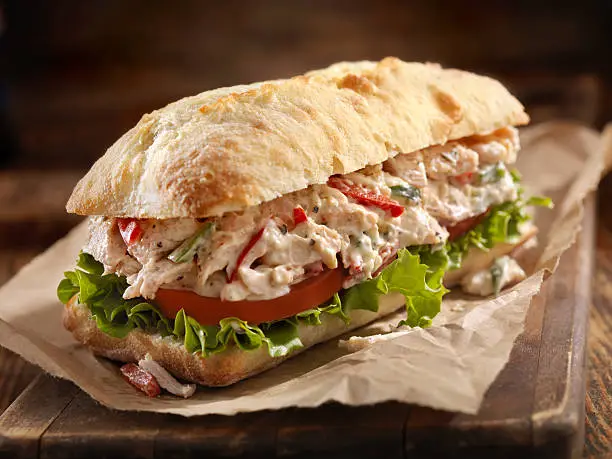 A Creamy Chicken Salad Sandwich with Red Peppers, Cucumber, Lettuce and Tomato on Ciabatta Bun - Photographed on Hasselblad H3D2-39mb Camera