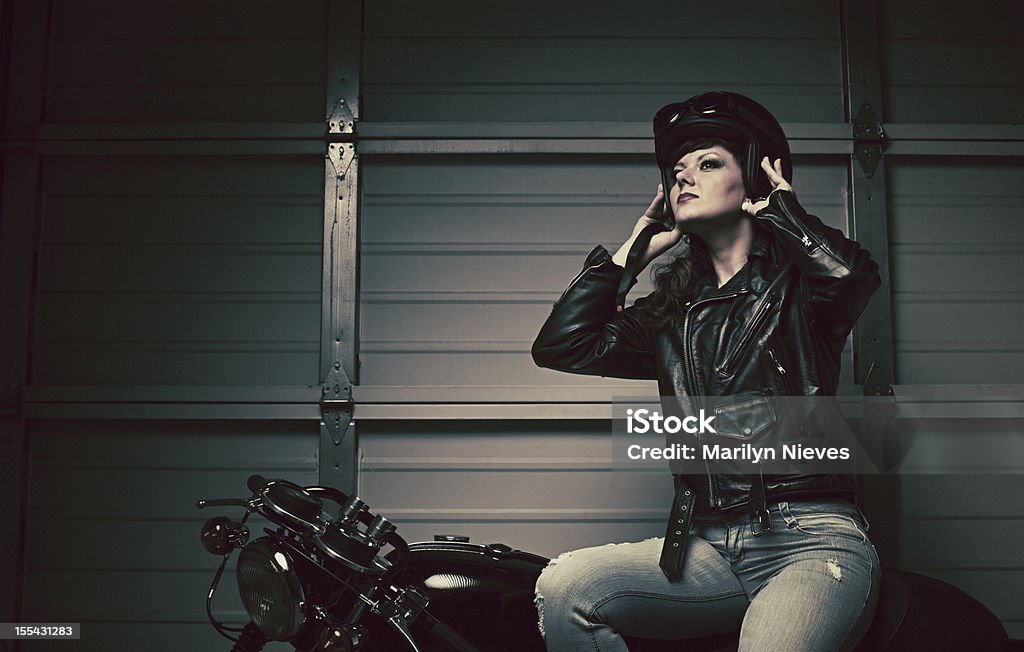 female biker taking off helmet  Adult Stock Photo