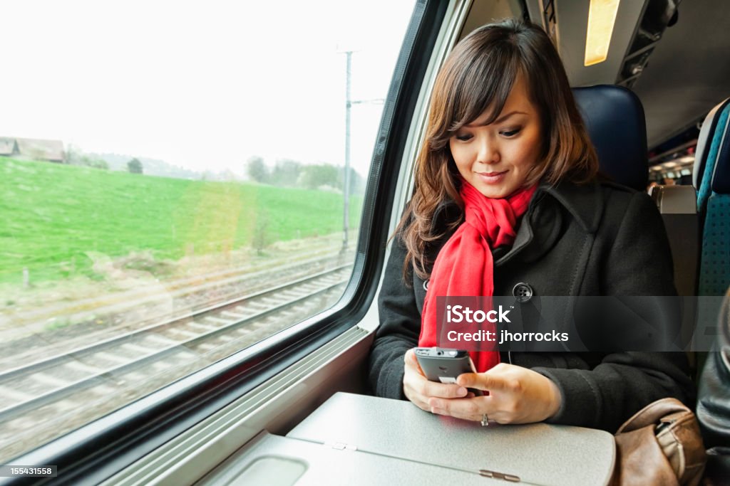 Junge asiatische Frau, die mit dem Zug - Lizenzfrei Eisenbahn Stock-Foto