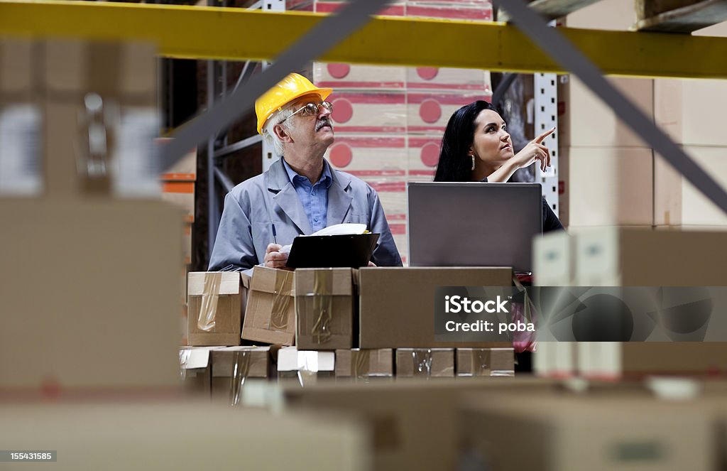 warehouseman e Inspetor Alfandegário está, do controlador, verificando o estoque do depósito - Foto de stock de Armazém royalty-free