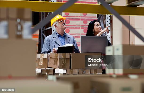 Foto de Warehouseman E Inspetor Alfandegário Está Do Controlador Verificando O Estoque Do Depósito e mais fotos de stock de Armazém