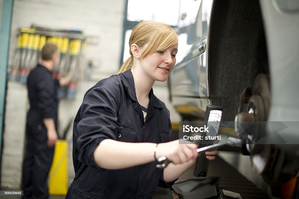 Adolescente ragazza lavorando sulla ruota di un'auto - Foto stock royalty-free di Adolescente