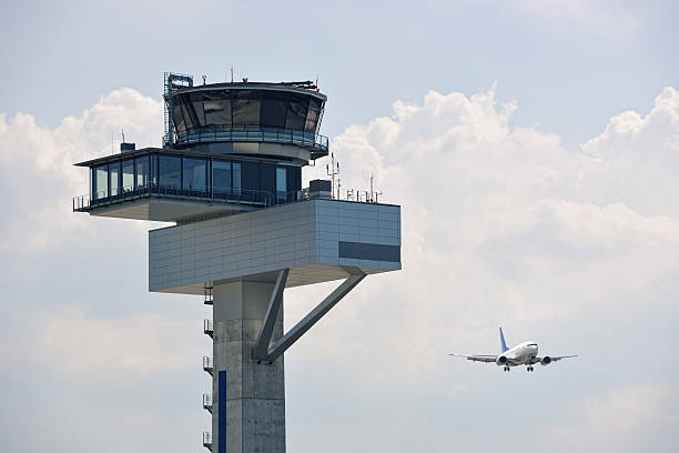 Air Traffic Control Tower and Approaching Aircraft Air traffic control tower and jet aircraft approaching to land. air traffic control tower stock pictures, royalty-free photos & images