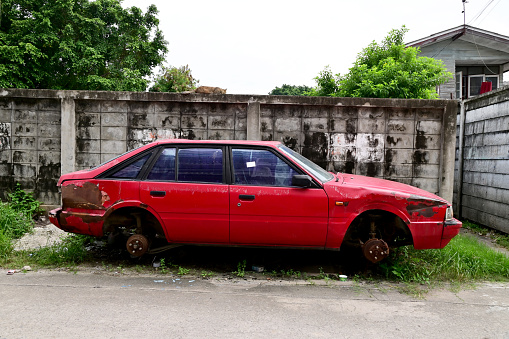 BANGKOK, THAILAND - July 20, 2023 : Old cars parked for a long time with dust in the garage (old car cemetery) in Thailand.