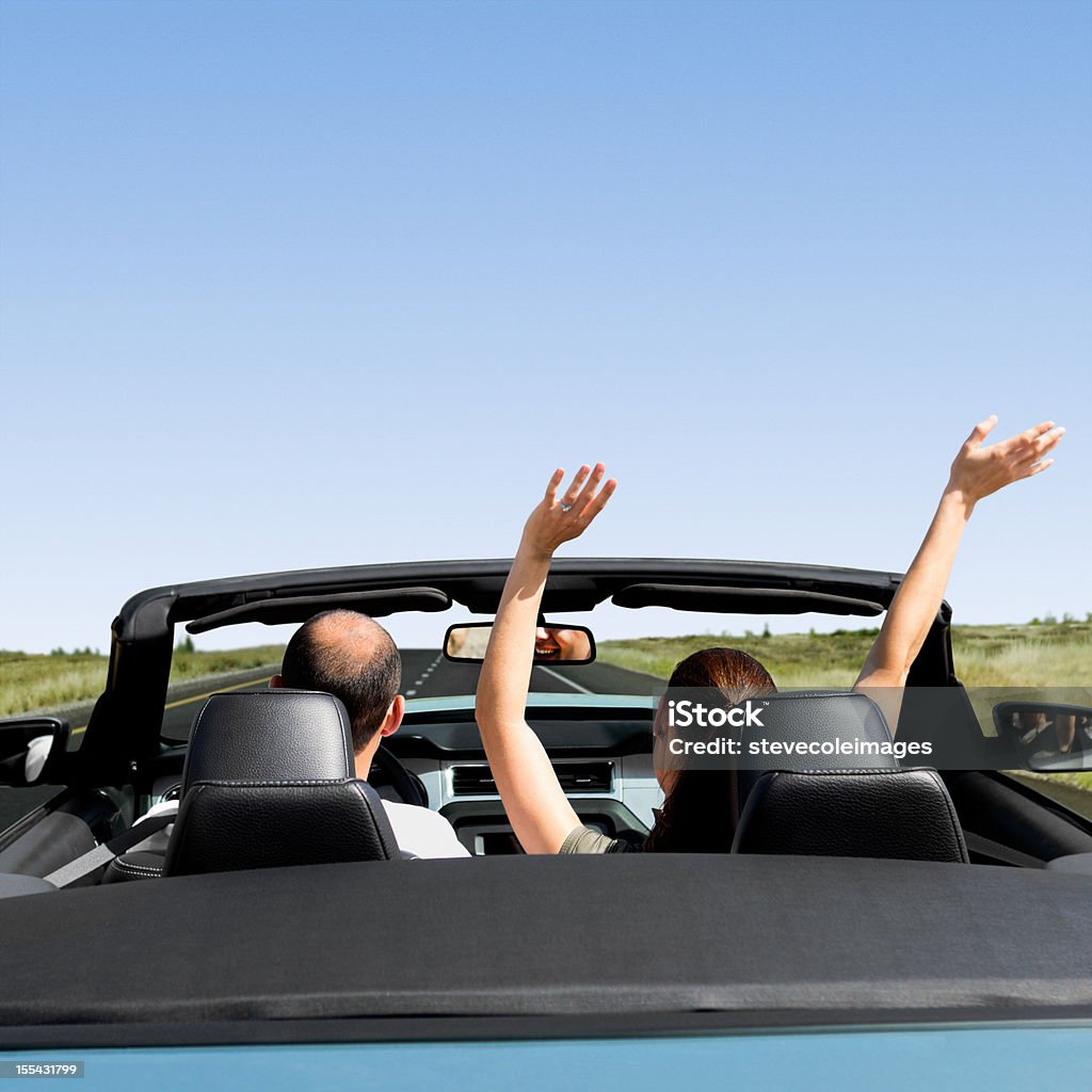 Raodtrip A couple in a convertible traveling down the road. 25-29 Years Stock Photo