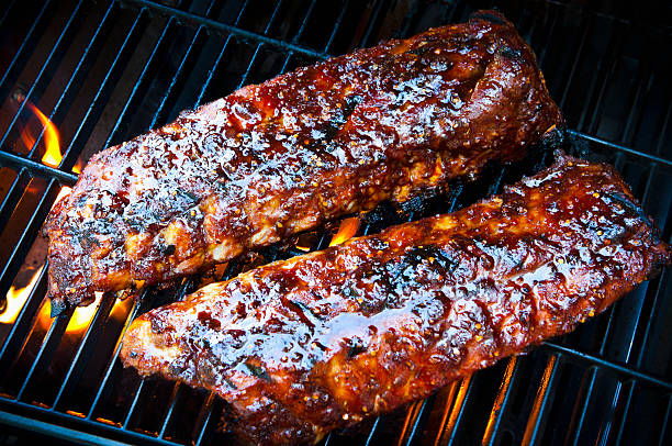 Barbecue Ribs Rack of baby back pork ribs on bbq grill. barbeque sauce photos stock pictures, royalty-free photos & images
