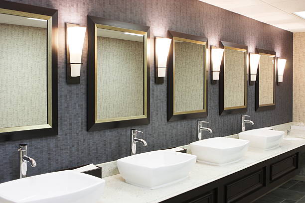 Restroom Luxury Hotel Restaurant Decor Sinks, faucets, mirrors and lighting sconces in a luxury hotel restaurant restroom. bathroom bathroom sink sink design stock pictures, royalty-free photos & images