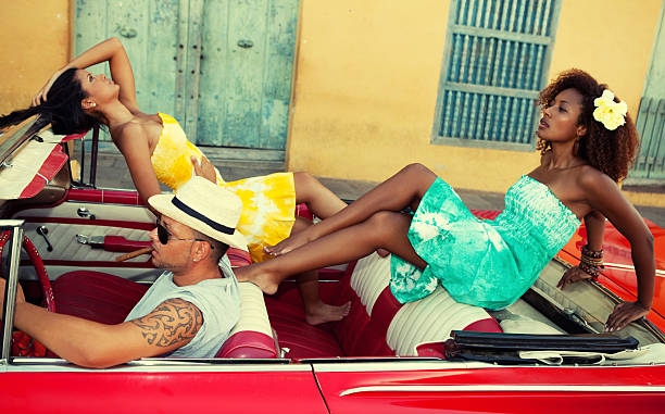 istock Two beautiful women and man posing with a red car 155432043
