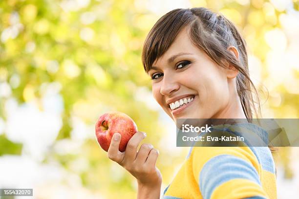 Cheerful Young Woman Eating An Apple Stock Photo - Download Image Now - Apple - Fruit, Eating, Women