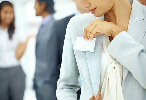 A young businesswoman pinning a nametag to her jacket - Copyspace