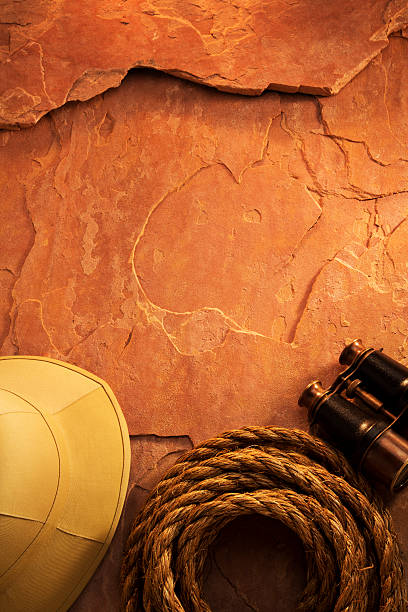 istock Antique Binoculars and Safari Hat with Rope on Red Rock 155432314