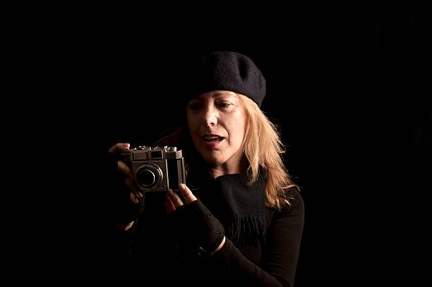 istock Woman Photographer Checking Her Retro Camera 155432420