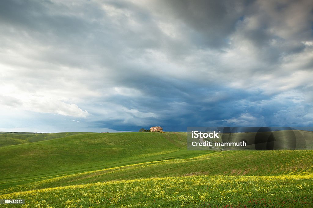Wzgórzach Toskanii pod Dramatyczne niebo - Zbiór zdjęć royalty-free (Budynek rolniczy)