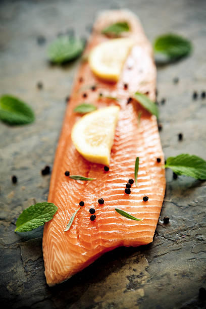 Trout fillet with lemon and capers on a stone surface