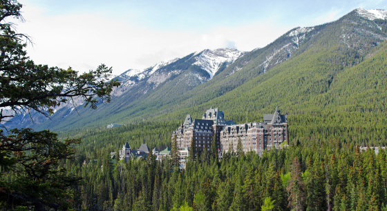 Banff Springs Hotel in late spring from the west side of the Bow River. The Rocky Mountains are in the background.