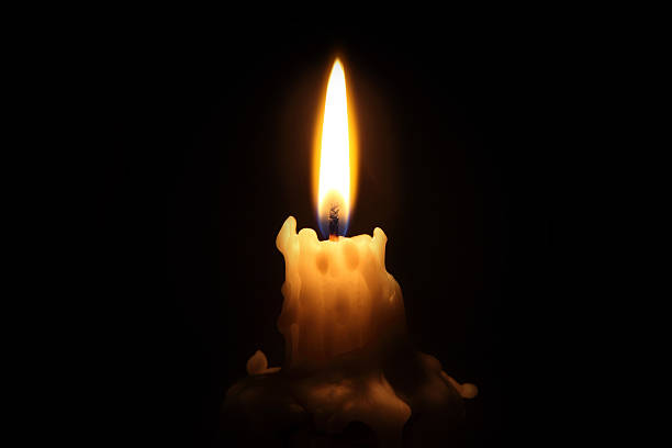 Bright waxy candle burns down Candle reaching the end of its life with lots of wax dripping down the sides and pooled at the bottom. candlelight stock pictures, royalty-free photos & images