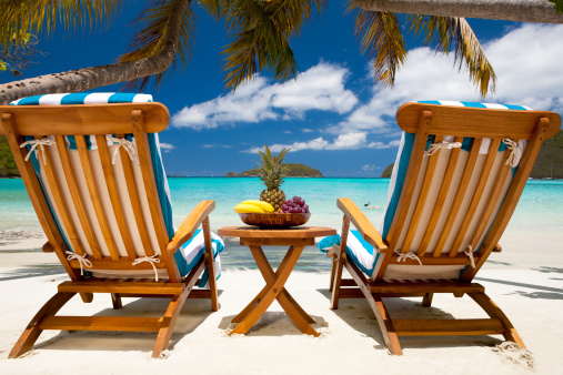 two teak recliner chairs and a table full of exotic fruit at a tropical Caribbean beach resort