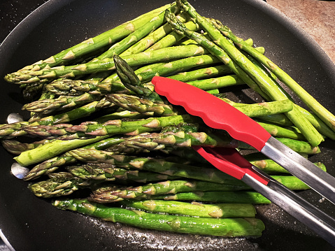 These asparagus spears are being seared in ghee.