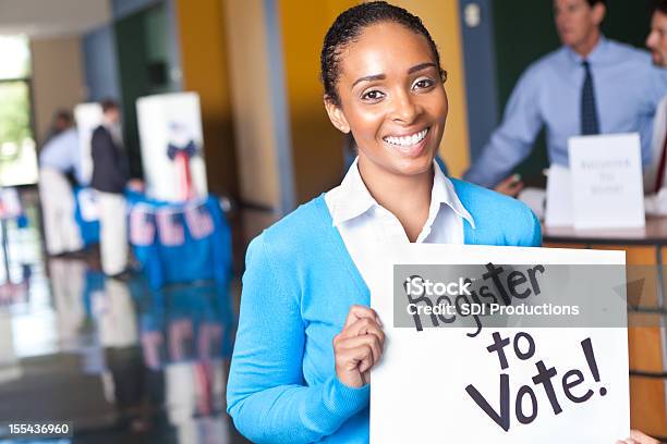 Giovane Donna Con La Registrazione Per Accedere Al Centro Di Voto Voto - Fotografie stock e altre immagini di Iscrizione nelle liste elettorali
