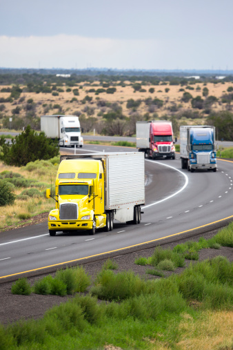 Four semi trucks convoy on the interstate