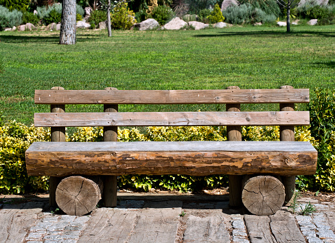 bench made of wood in the autumn forest among fallen leaves in the rain