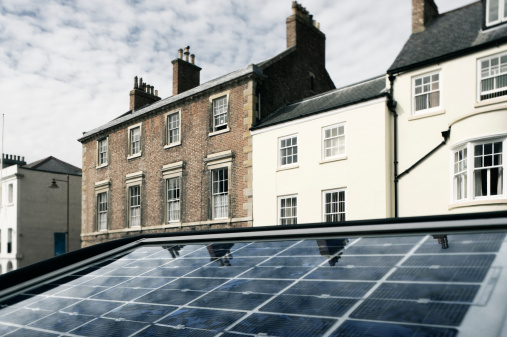 The solar panel of a parkmeter reflects the sky in a street of Durham, England
