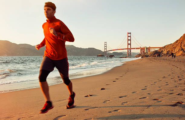 golden gate run - men footprint beach sunset zdjęcia i obrazy z banku zdjęć