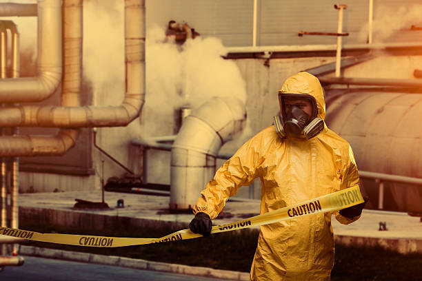 Worker Man in protective workwear with Caution cordon tape biochemical weapon photos stock pictures, royalty-free photos & images
