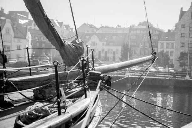 Black and White image of a Sailboat Docked in a European City