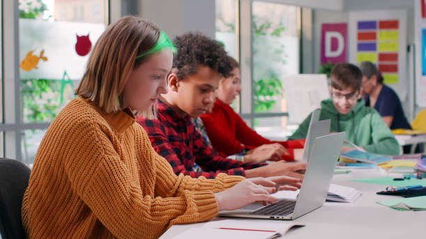 istock Multiethnic teenage students type on laptop in modern classroom 1554380733