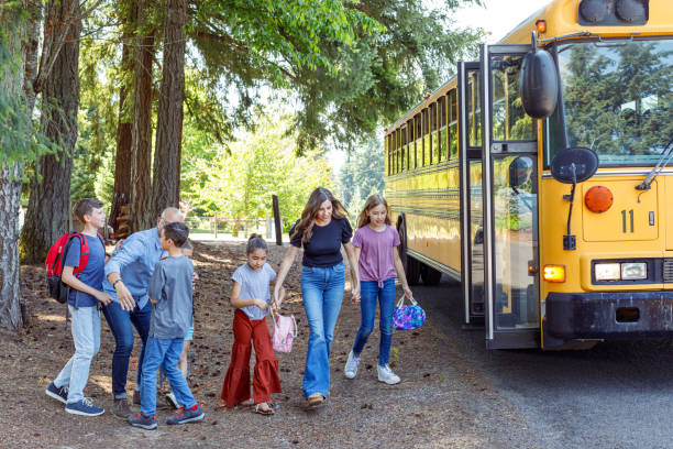 istock Parents greeting children at bus stop after school 1554382885