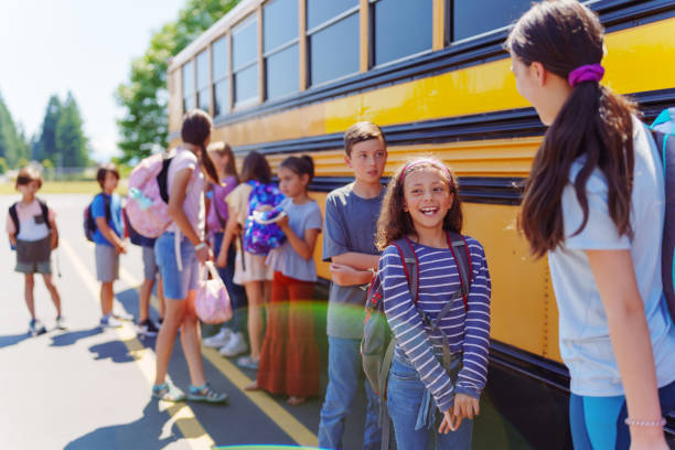 istock Students waiting to board school bus 1554383085