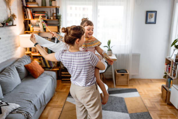 istock Mother and daughter dancing at home, having fun together. 1554383409