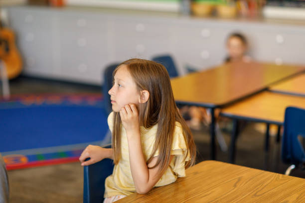 istock Elementary girl listening to class lecture 1554383417