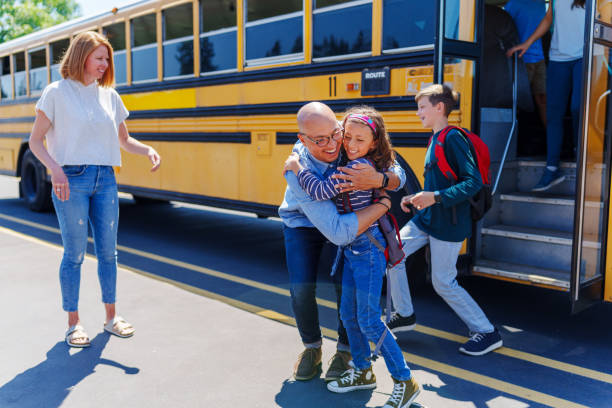 istock Loving father greeting his daughter with a hug after school 1554383437