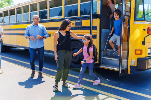 istock Hispanic mom greeting her daughter at school bus stop 1554383440