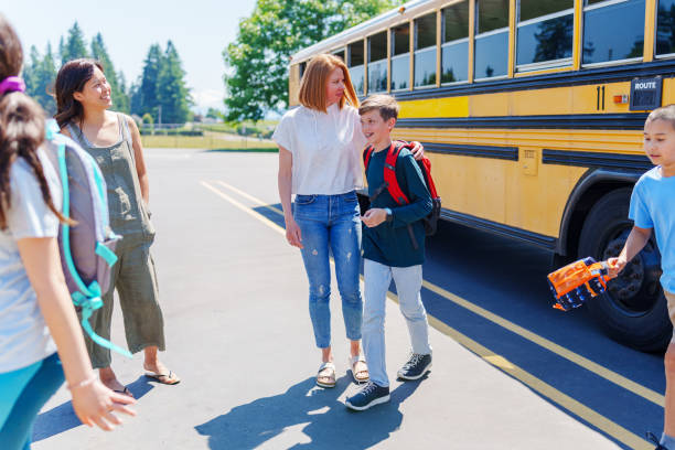 istock Tween boy at school bus stop with his mom 1554383464