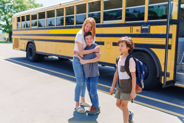 istock Loving mom greeting her son with a hug after school 1554383465