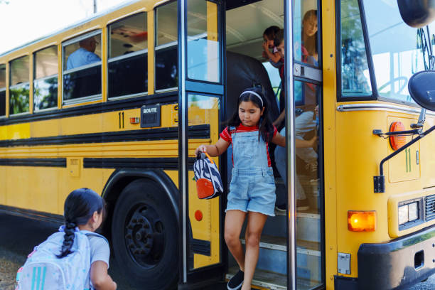 istock Eurasian girl getting off school bus 1554383484
