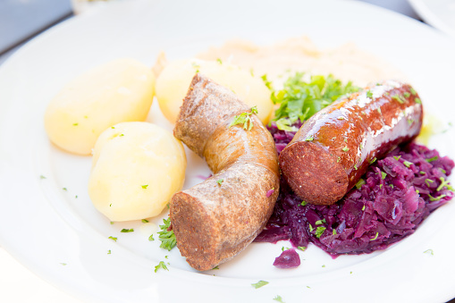 Two types of bratwurst sausage on a plate with potatoes, beets.  Norwegian cuisine.