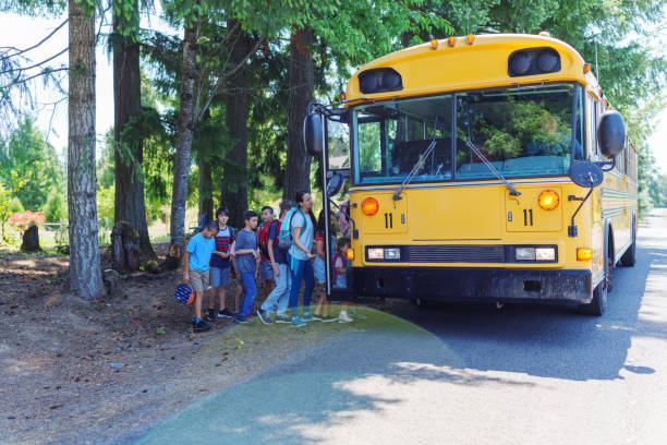 istock Students in queue boarding school bus in rural neighborhood 1554383996