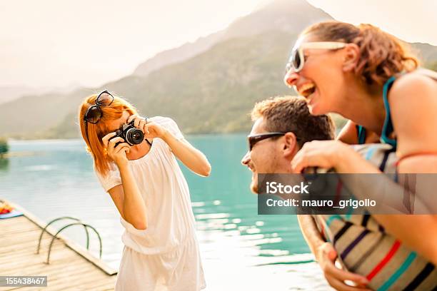 Foto de Mulher Tirando Foto De Um Casal e mais fotos de stock de 20 Anos - 20 Anos, 20-24 Anos, Adulto